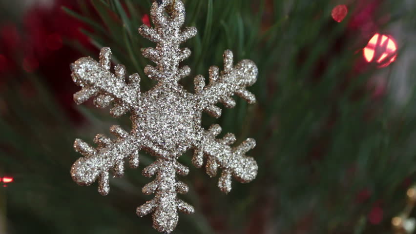 decorative snowflake on christmas tree decorated with flashing garlands