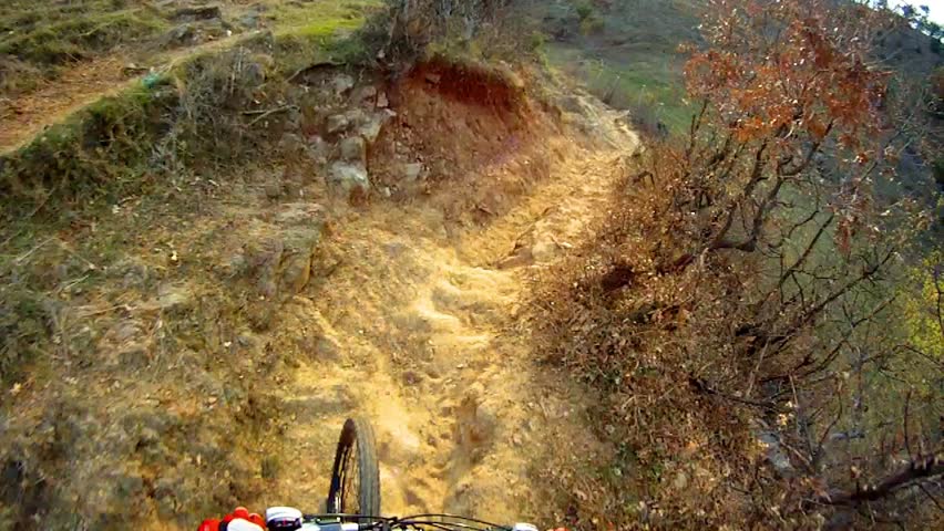 Do Downhill front view. Ride a bike over extreme terrain pov.