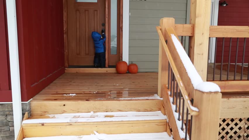 A toddler playing outside his home after a snowstorm
