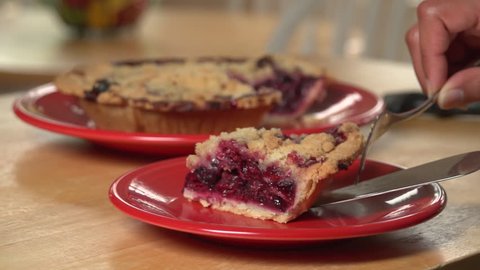 Close up woman's hands serving up a slice of berry pie Stock Video