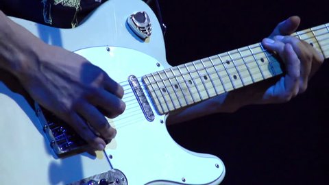 Electric Guitar at Rock Concert. Slow Motion at a rate of 240 fps. Close-up of fingers guitarist strumming an electric guitar