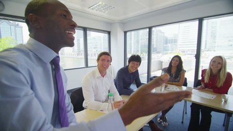 Attractive mixed ethnicity business team in boardroom meeting or training seminar.