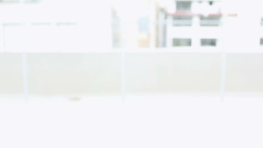 Anxious man peering over desk in bright room