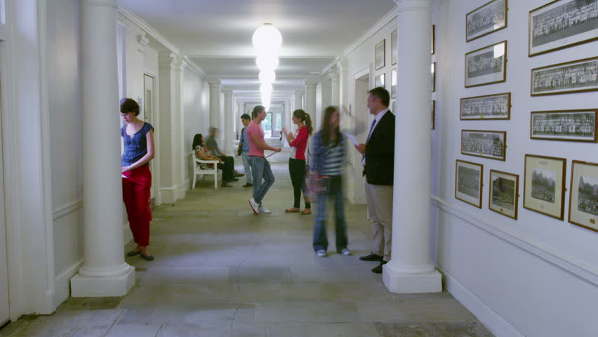 Time lapse of busy students and teachers walking through the hallway of a university building.