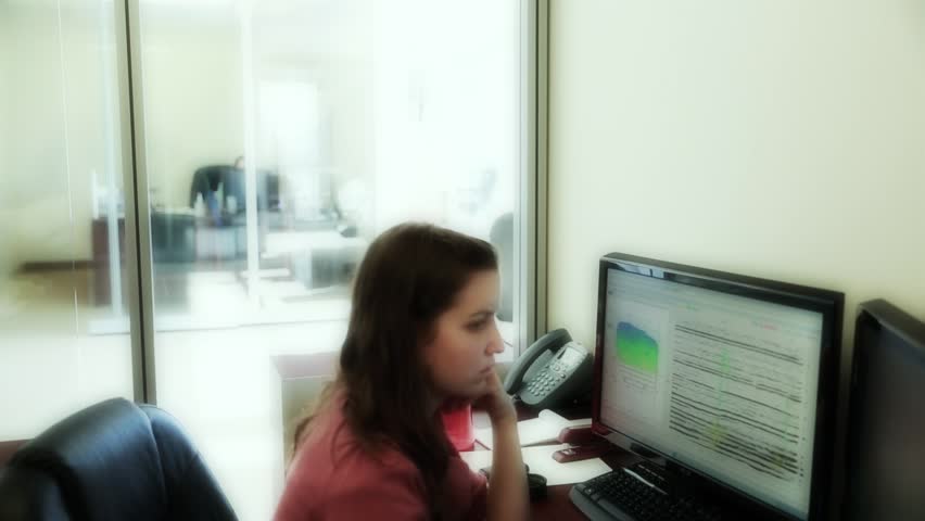 A woman geologist working at the computer in her office