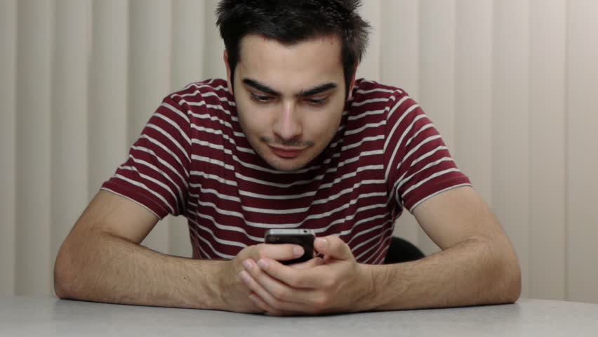 Young man texting with his smartphone.