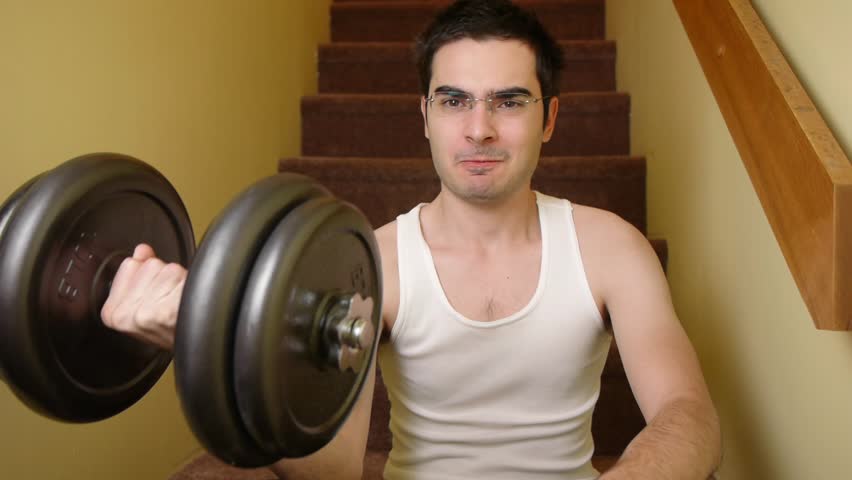 Young man exercising at home with dumbbells