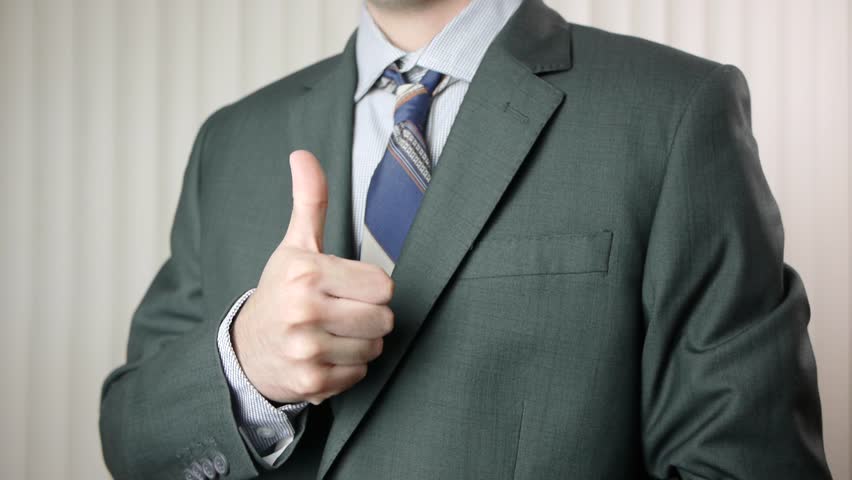 Young businessman giving a thumbs up to the camera