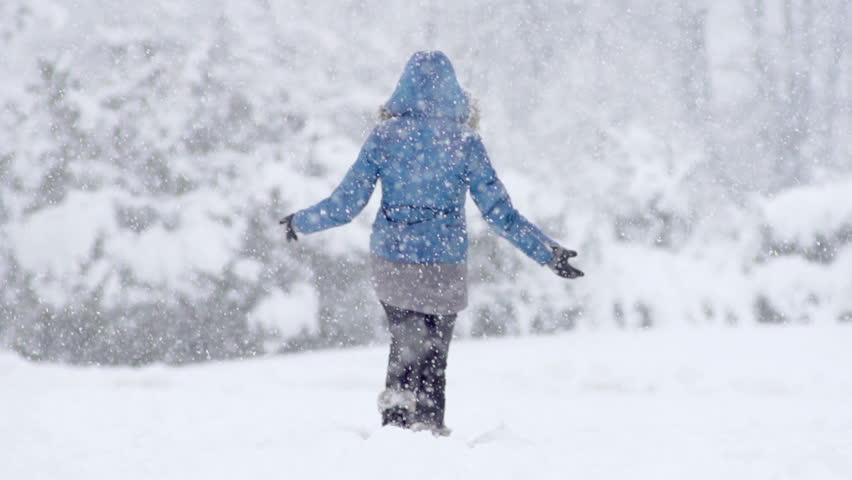 Slow Motion Of Young Woman Having Fun Kicking Snow During Snow Blizzard In Park