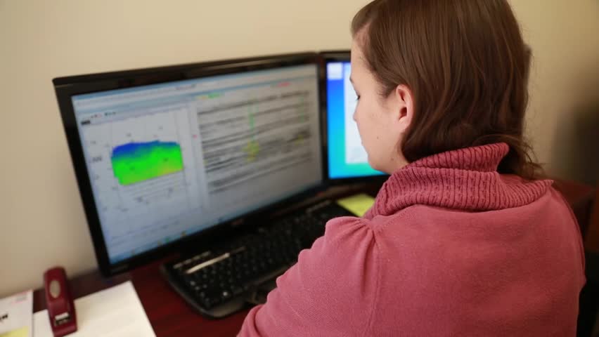 A woman working in her office as a geologist on her computer