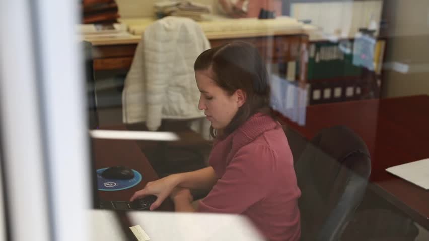 A woman working in her office as a geologist on her computer