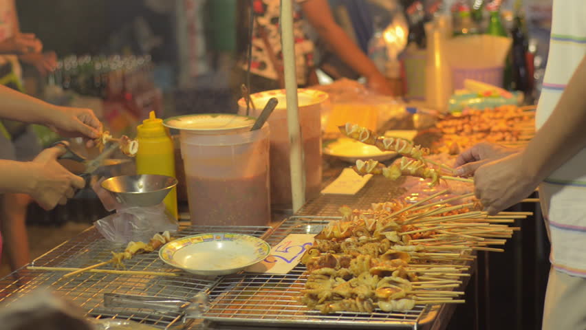 The stall of a street vendor selling grilled squid in Bangkok, Thailand.