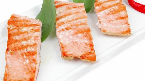 roasted salmon pieces with pepper and lemon on basil leaf over ceramic plate 1920x1080 intro motion slow hidef hd