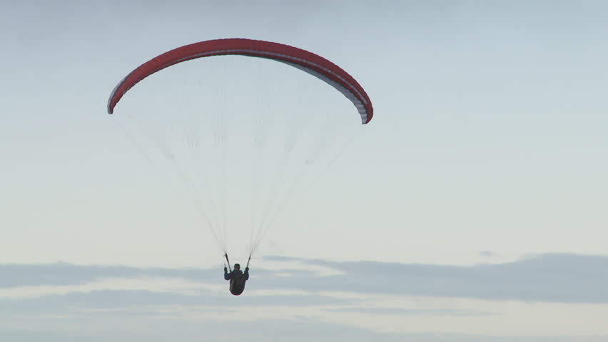 A paraglider soaring along a ridge line gains lift. 