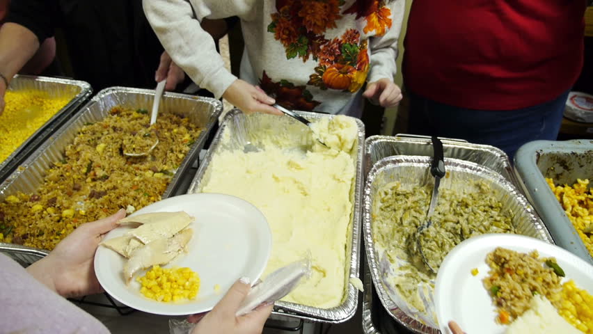 Food being served at a soup kitchen on Thanksgiving.