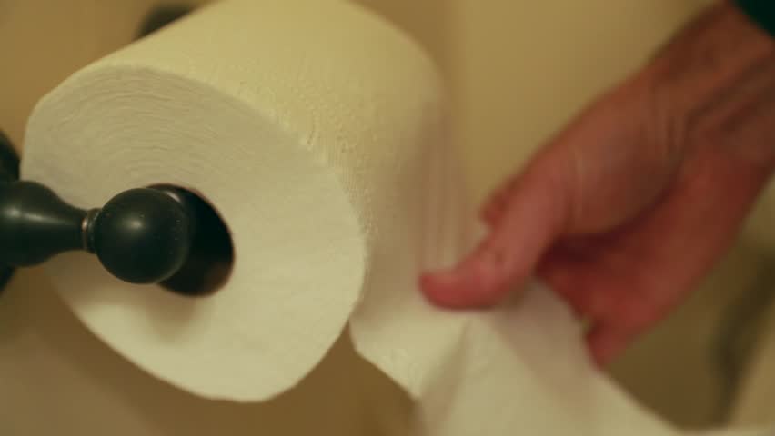 A hand grabbing toilet paper