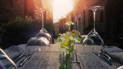 Table with wine glasses of wedding arrangement when sunset falls over ancient borgo