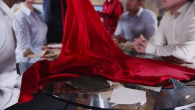 Team of fashion designers or retailers in a business meeting. They are checking the quality and design of an elegant red gown.  - Powered by Shutterstock - Get 15% off with code: PIKWIZARD15