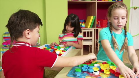 Group of preschool children making a puzzle together