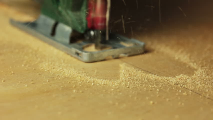 Electric fretsaw is sawing plywood. Close-up. Perspective view