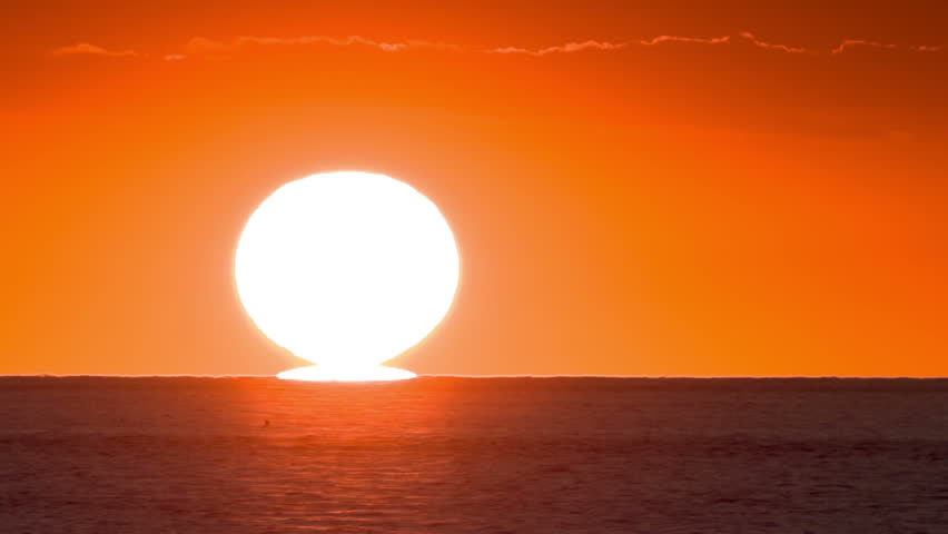 Timelapse of large, bright sun down on sunset over the sea. High quality, Raw