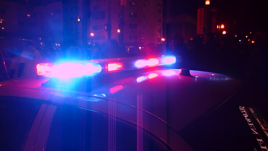PORTLAND, OREGON - CIRCA 2013: Police car lights flashing with many people