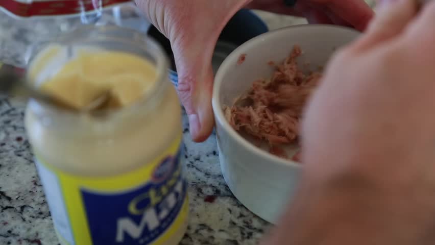 A man makes a tuna fish sandwich