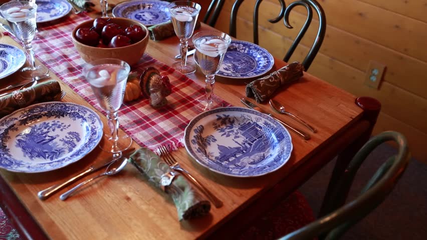 A dining room table set for a thanksgiving dinner party