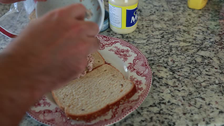 A man making a tuna fish sandwich for lunch