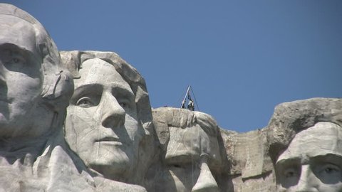 Mount Rushmore with men standing on head