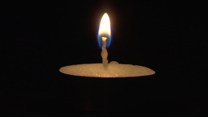 Close-up of burning candle isolated on black background
