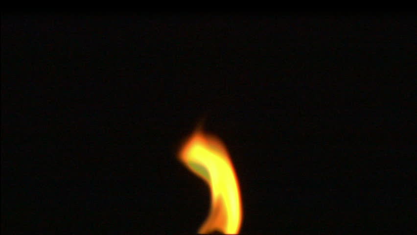 Close-up of burning candle isolated on black background