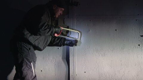 Burglar breaks padlock on the gate of the garage at night