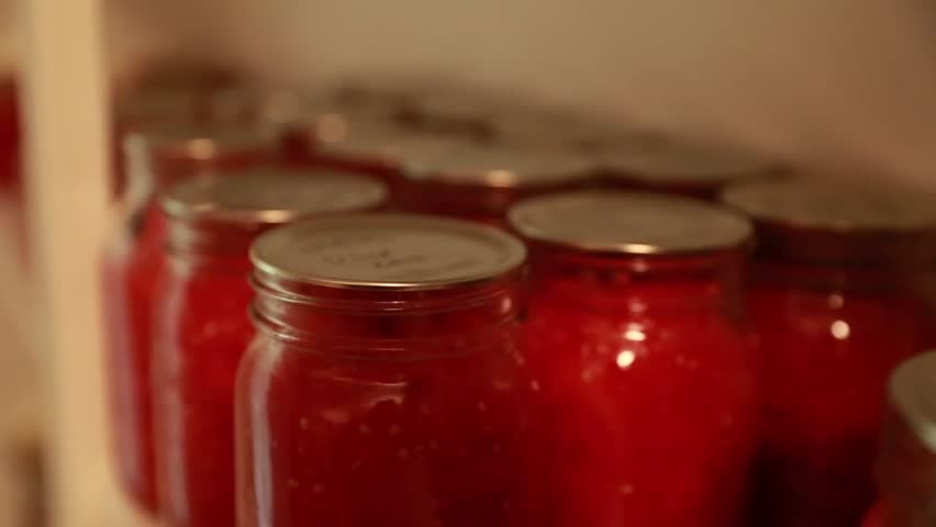 Food canned in mason jars on shelves in a storage room in a house