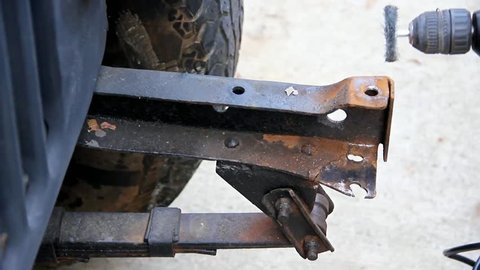 Wire Wheel In An Electric Drill Removes Rust Off An Old Vehicle Frontal Frame Section