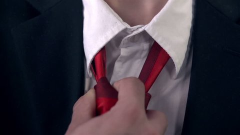 Business Man in Black Suit Untying the Red Tie