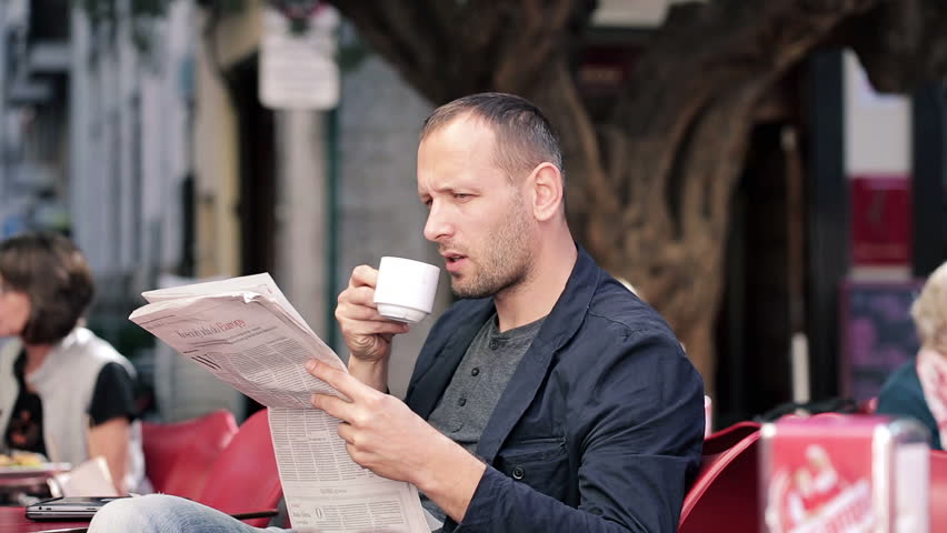 He reads magazines. Человек читает в кафе. Человек читает газету. Люди читающие газеты в кафе. Парень читает газету в кафе.