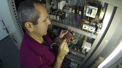 Electrician Inspect Electrical Power Feeds.Plant electrician testing voltage in the control cabinet.HD1080p.