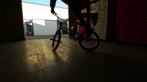 BMX rider doing tricks a commercial plant silhouetted  Stock Video
