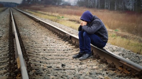 Sorrowful boy on the railway
