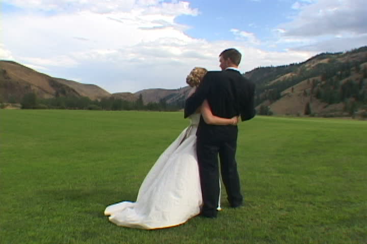 Unrecognizable Bride and Groom hold each other in Washington State Valley after