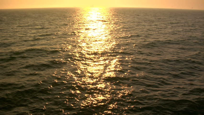Wide shot of a golden ocean in slow motion