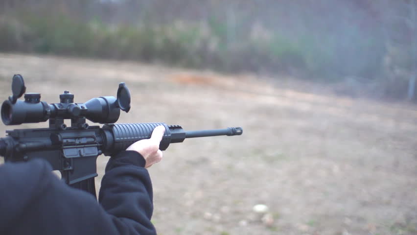 Military style Assault Rifle being fired in real time and slow motion by a man