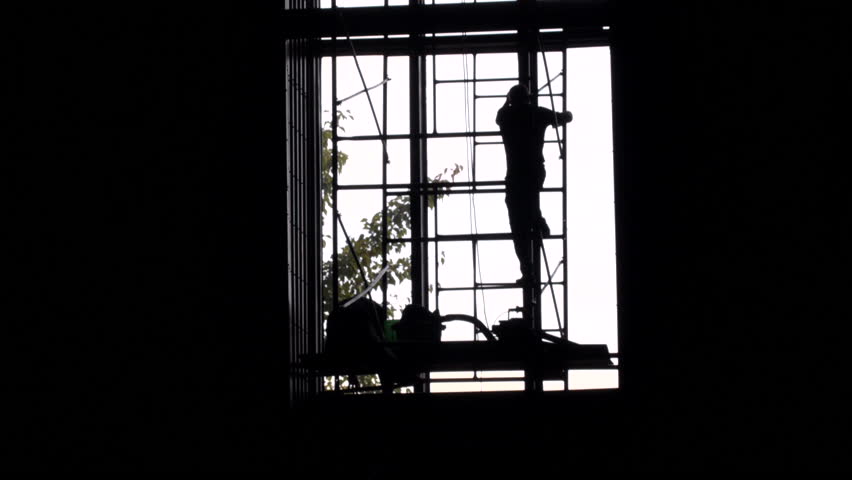 Time lapse of men working on a large window