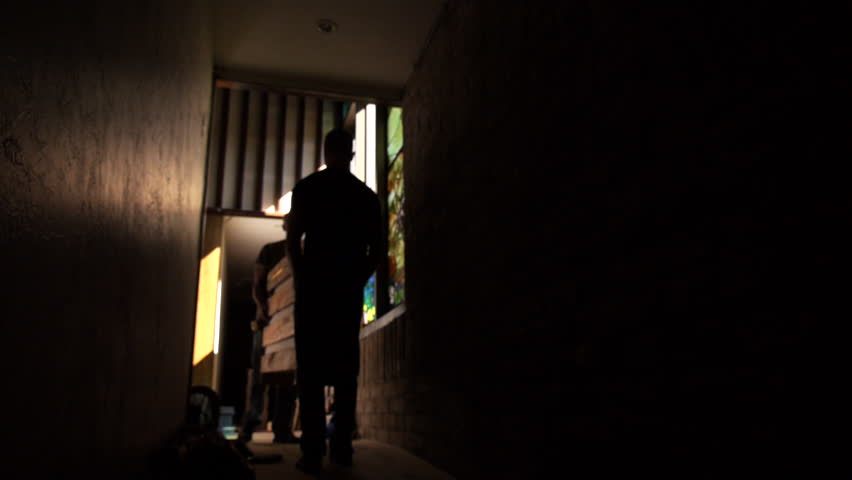 Men carry large wooden box down dimly lit corridor