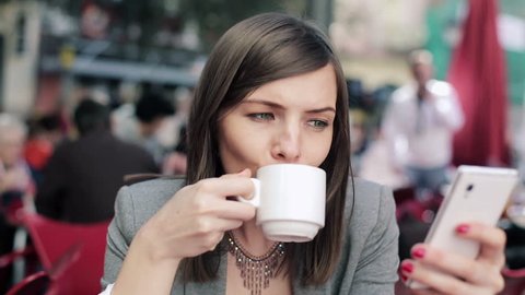 Businesswoman with smartphone drinking coffee in cafe
 Stock Video