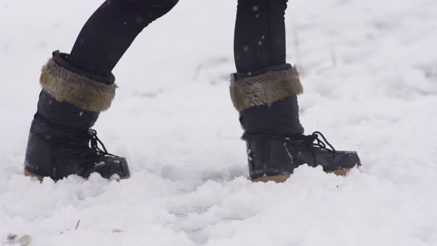 Slow Motion Of Black Female Snow Boots Walking Through Fresh Snow On A Snowy