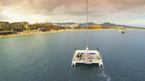 Catamaran aerial chase on the ocean at sunset in Cabo San Lucas Mexico