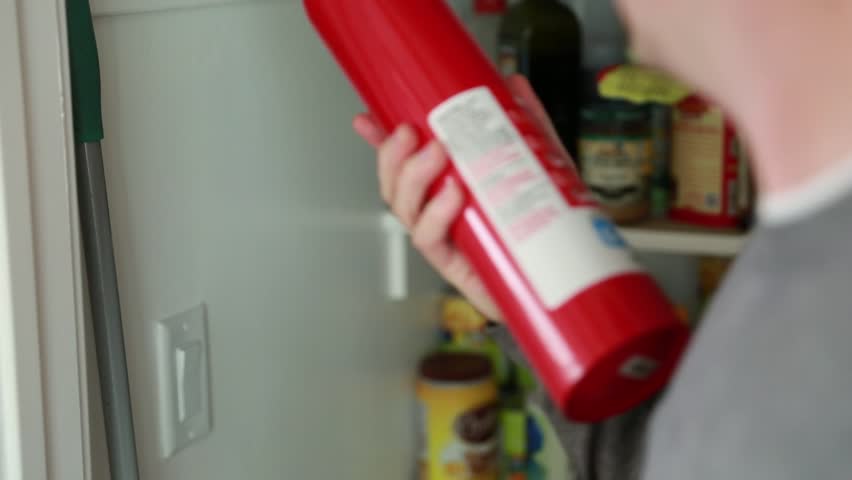 A man uses a fire extinguisher that he gets from the pantry