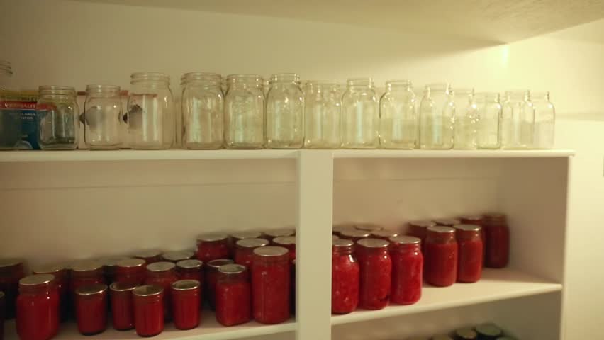 Food canned in mason jars on shelves in a storage room in the basement